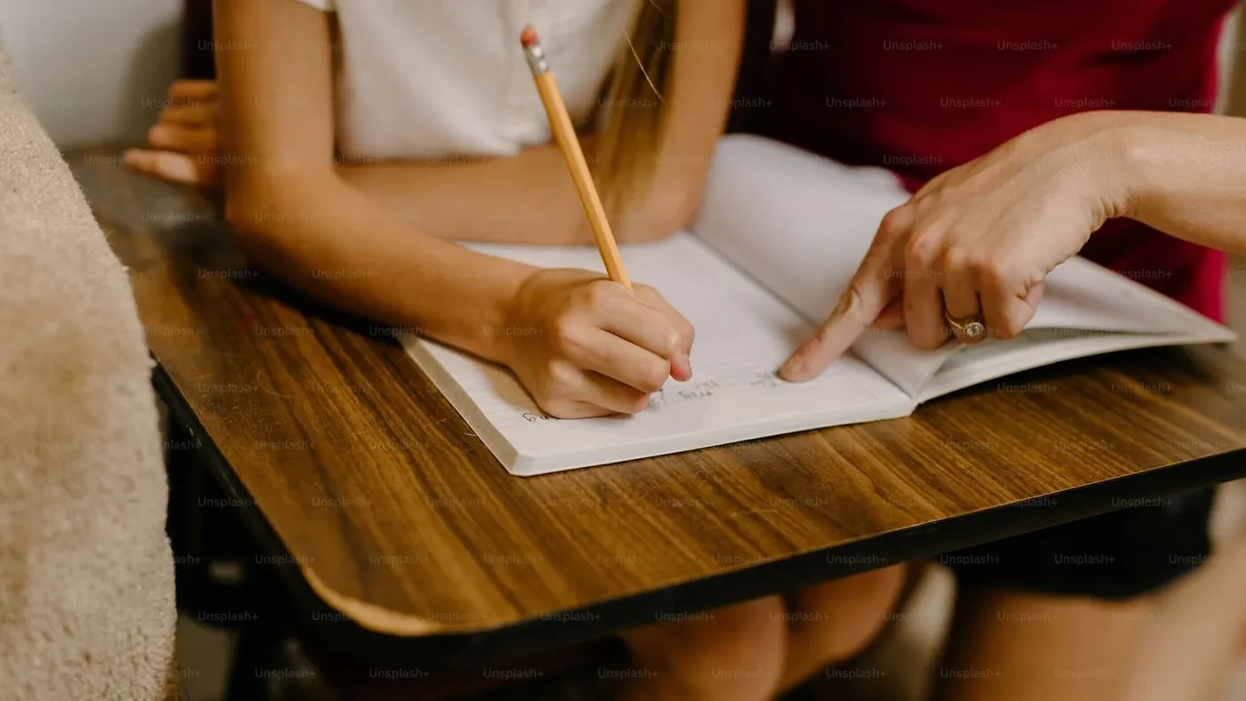 Student writing on paper at a desk